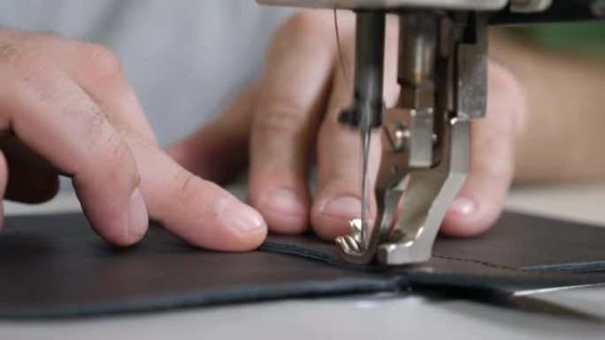 缝制皮革制品DIY手工制作，包，商务，工艺。小型私人皮革制造。雕刻皮包制作车间-工匠在缝纫机上缝制皮