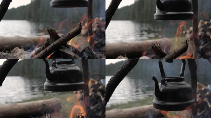 山湖周围篝火上的老式茶壶特写。