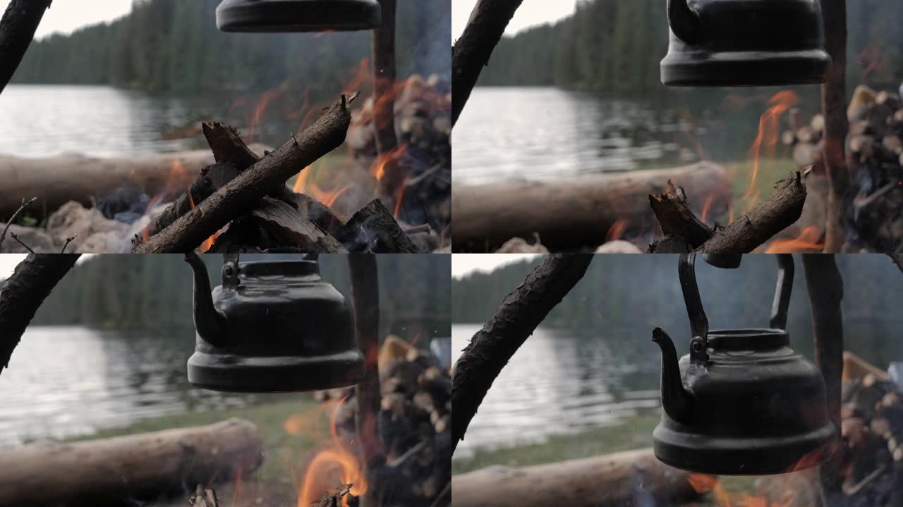 山湖周围篝火上的老式茶壶特写。