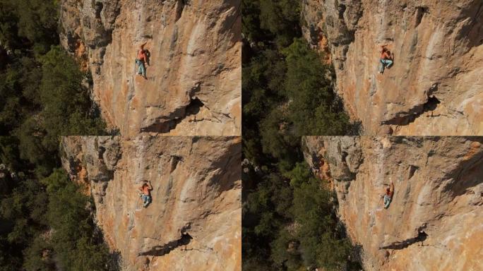航拍镜头。强壮肌肉男无人机的视野在垂直石灰岩岩壁上攀登挑战性的攀岩路线