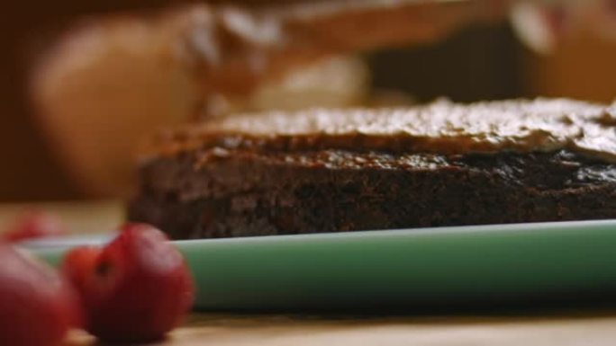 用花生酱从巧克力蛋糕上涂抹面团。4k视频