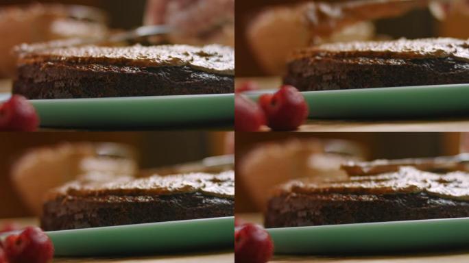 用花生酱从巧克力蛋糕上涂抹面团。4k视频