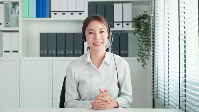 亚洲美女视频电话与人力资源经理进行面试。有吸引力的女性戴着耳机，使用笔记本电脑进行虚拟在线会议与办公