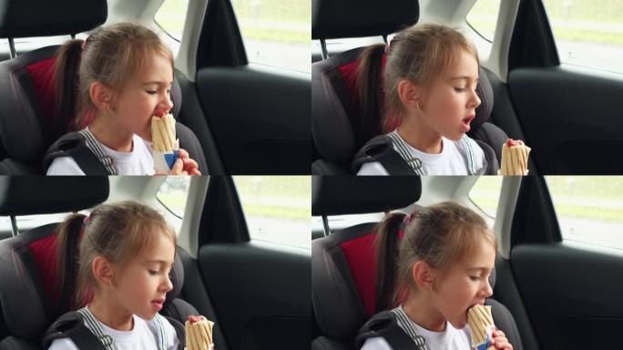 一个五岁的女孩在汽车安全座椅上系安全带，用香肠吃法式面包