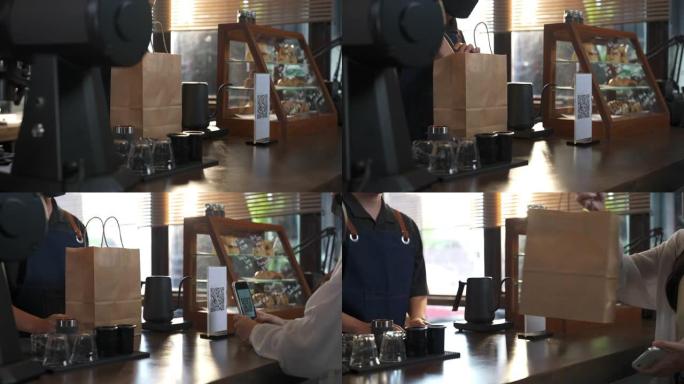 4k亚洲男子咖啡师戴防护面罩，以非接触式付款向客户发出外卖订单。