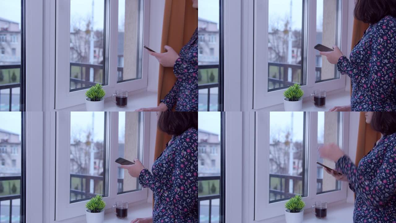 一个手里拿着电话的黑发女孩来到窗户看街道，侧视图，复印空间