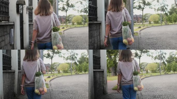 年轻女子在城市街道上带着环保袋行走