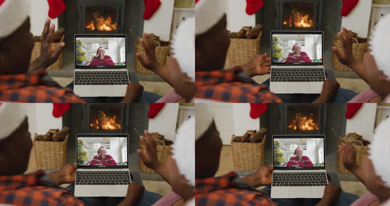 非洲裔美国夫妇挥舞并使用笔记本电脑与屏幕上的女人进行圣诞节视频通话