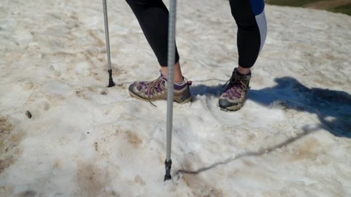 白雪皑皑的山坡上有登山杖的徒步旅行者