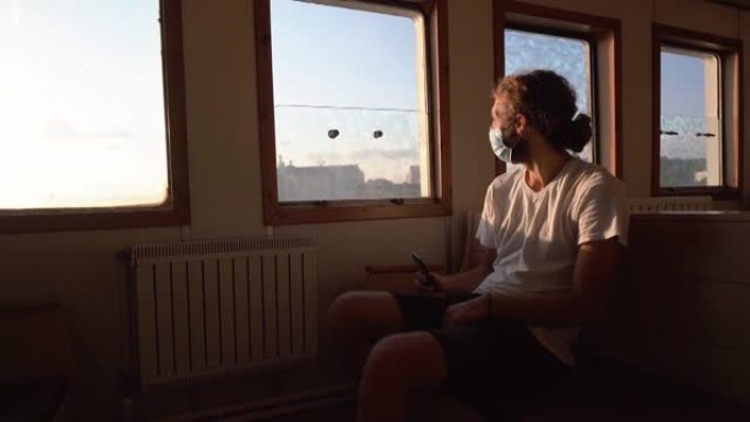 男子在伊斯坦布尔的博斯普鲁斯海峡乘渡轮旅行时使用智能手机