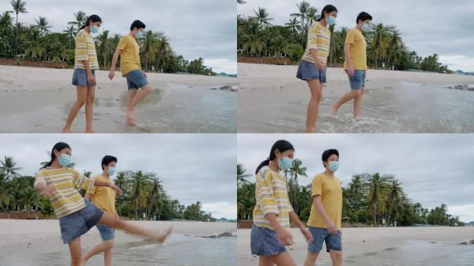 快乐的亚洲儿童一起在沙滩上踢水，生活方式理念。
