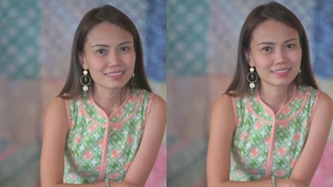 马来西亚华人美女精品小企业主肖像在她蜡染旗袍面料纺织品收藏零售店前看着相机微笑