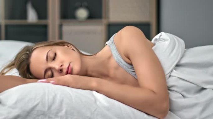 疲惫的女人打哈欠捂着嘴的手落在舒适的棉白色枕头上享受睡眠特写