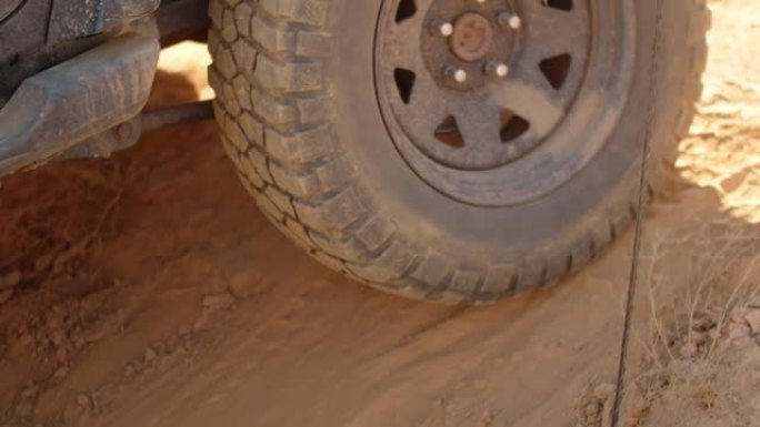 在沙土地形上行驶的suv大轮特写镜头。在沙漠上乘车旅行的概念