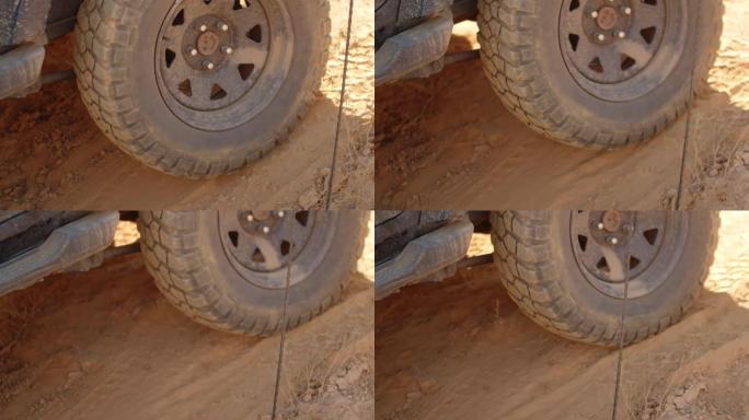 在沙土地形上行驶的suv大轮特写镜头。在沙漠上乘车旅行的概念