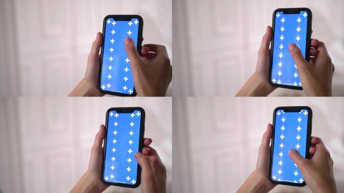 女人在智能手机应用程序中滑动，上下滚动蓝色色度键屏幕。