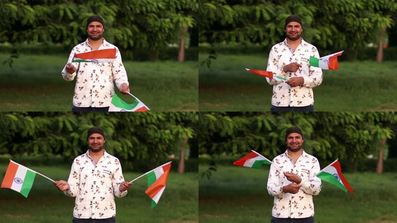 年轻的印度男人双手拿着三色旗