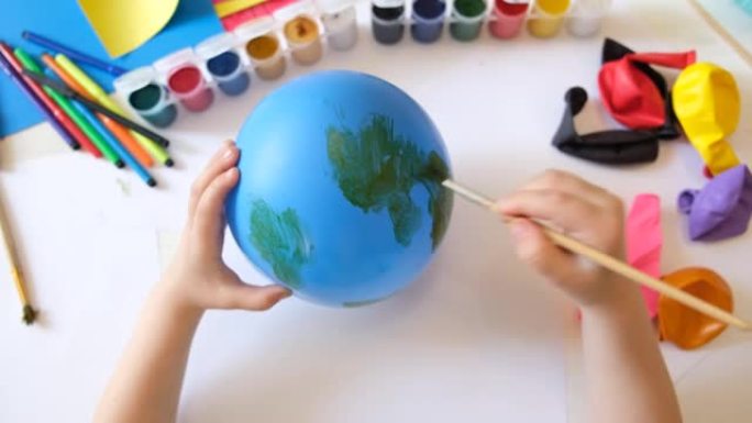 儿童在气球上绘制油漆图案。有趣的玩具。工艺概念。艺术学习与教育