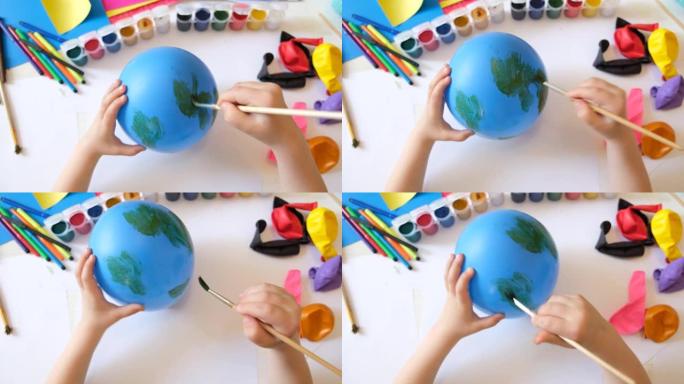 儿童在气球上绘制油漆图案。有趣的玩具。工艺概念。艺术学习与教育