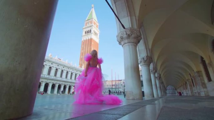 威尼斯圣马可广场穿着粉色优雅连衣裙的女孩