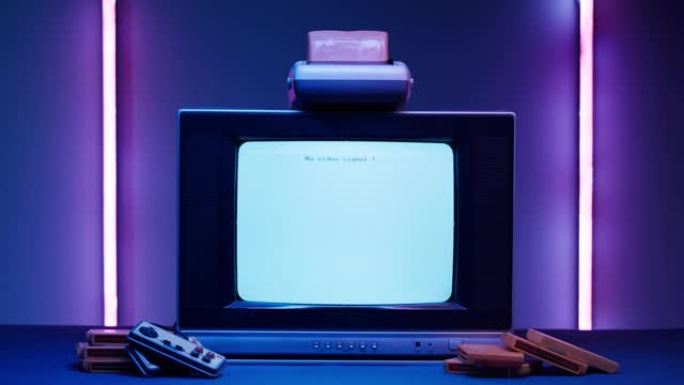 紫色霓虹灯背景的白色屏幕旧电视。复古playstation老式电视和墨盒的特写镜头。古董视频游戏，怀