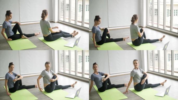 两名健康女性在家与在线老师一起做瑜伽