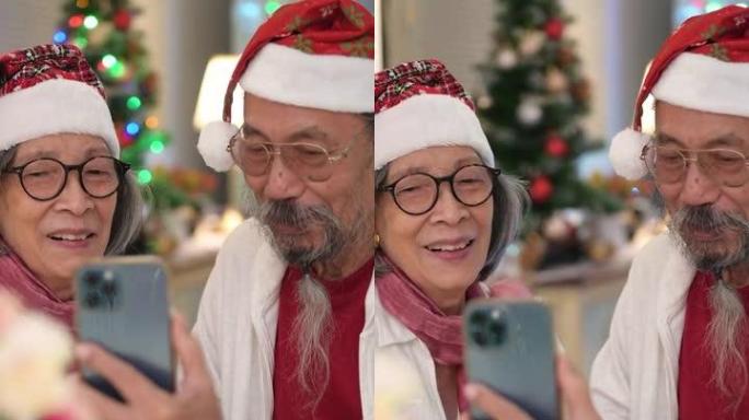 亚洲老年夫妇在圣诞节期间使用数字平板电脑或智能手机进行视频通话