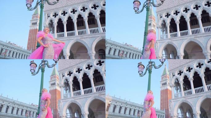 穿着粉红色连衣裙的女孩在圣马可塔前的威尼斯广场上移动