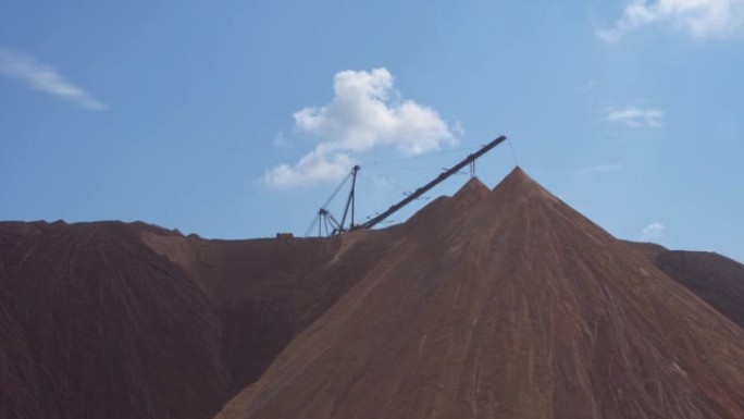 采矿业收盘。Telestacker处理钾肥废料堆的矿石特写，采石场中盐和钾肥的提取以及矿石的加工