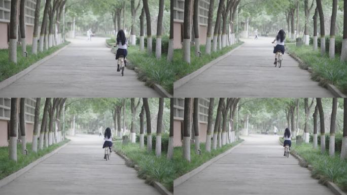 年轻的亚洲妇女骑自行车上学