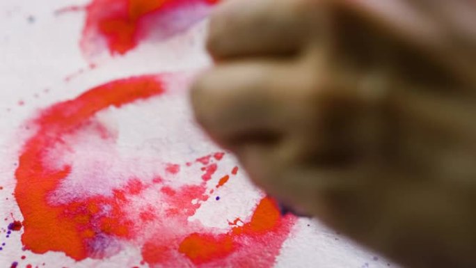 女艺术家的手的特写镜头用水彩画了一颗红色的心。4K