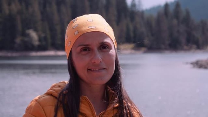 湖岸带着头巾微笑的女人的肖像。