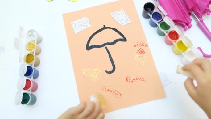 秋天的卡片。儿童绘画伞和抽象的秋天公园使用海绵和鸟羽毛像画笔