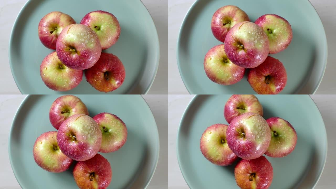 有机苹果放在转动的厨房桌子上的盘子里