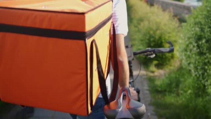 在城市里用自行车运送食物的无法识别的送货员的高角度视图