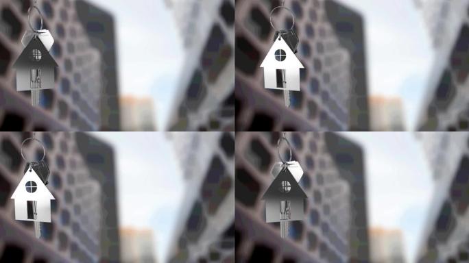银屋钥匙扣和钥匙的动画，悬挂在模糊的城市高层建筑前