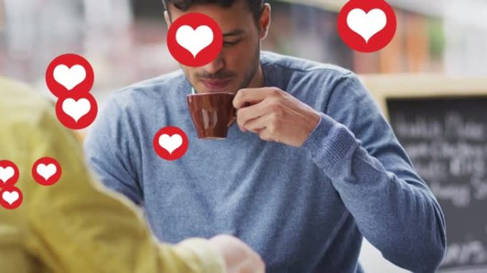 心脏图标的动画漂浮在快乐的高加索夫妇交谈和喝咖啡