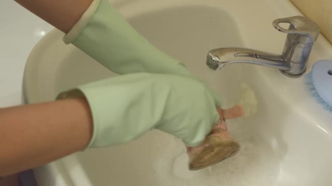 戴手套的女人在浴室洗脏童鞋