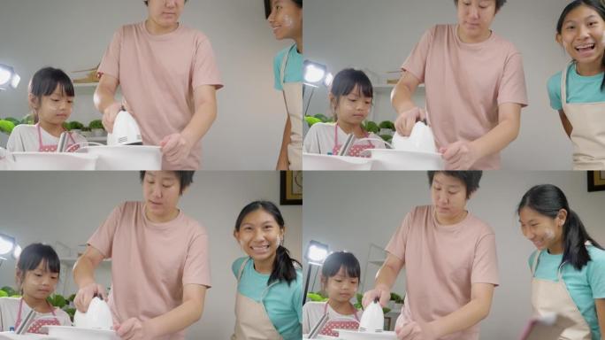 亚洲儿童在家与姐姐一起混合面团制作自制饼干，生活方式理念。