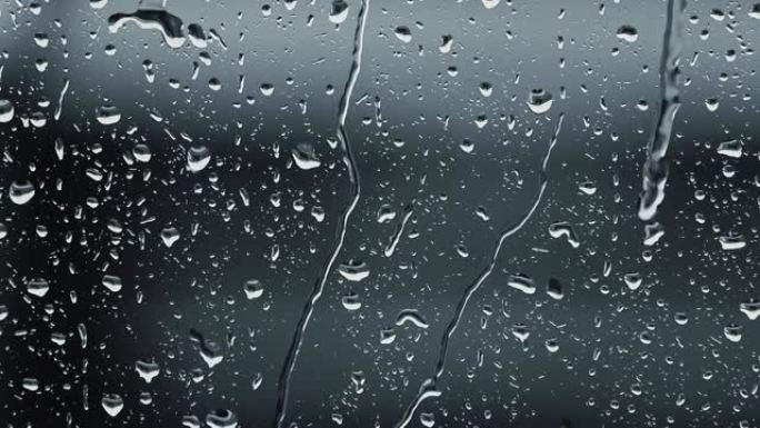 玻璃上水滴的特写。透明清晰的大雨背景。雨滴溅到窗户上。在玻璃表面上滴水。雨夜概念 ..