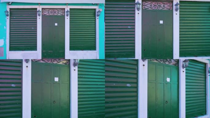 带有绿色锻造门和百叶窗的蓝屋立面