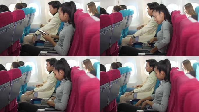 女乘客在飞机上关闭手机并系好安全带，旅行和度假概念