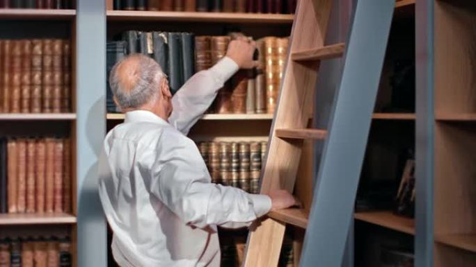 沉思的70年代老人在书柜公共图书馆选择古书使用木楼梯