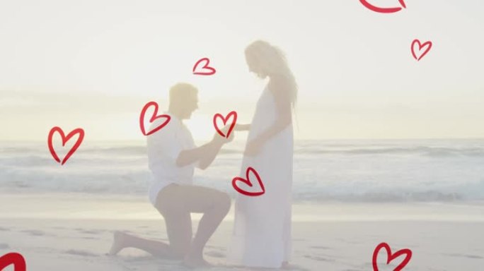 在海滩上求婚的高加索人身上的红心动画