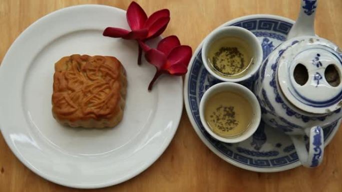 自然光下有月饼和红花的中国茶具，背景