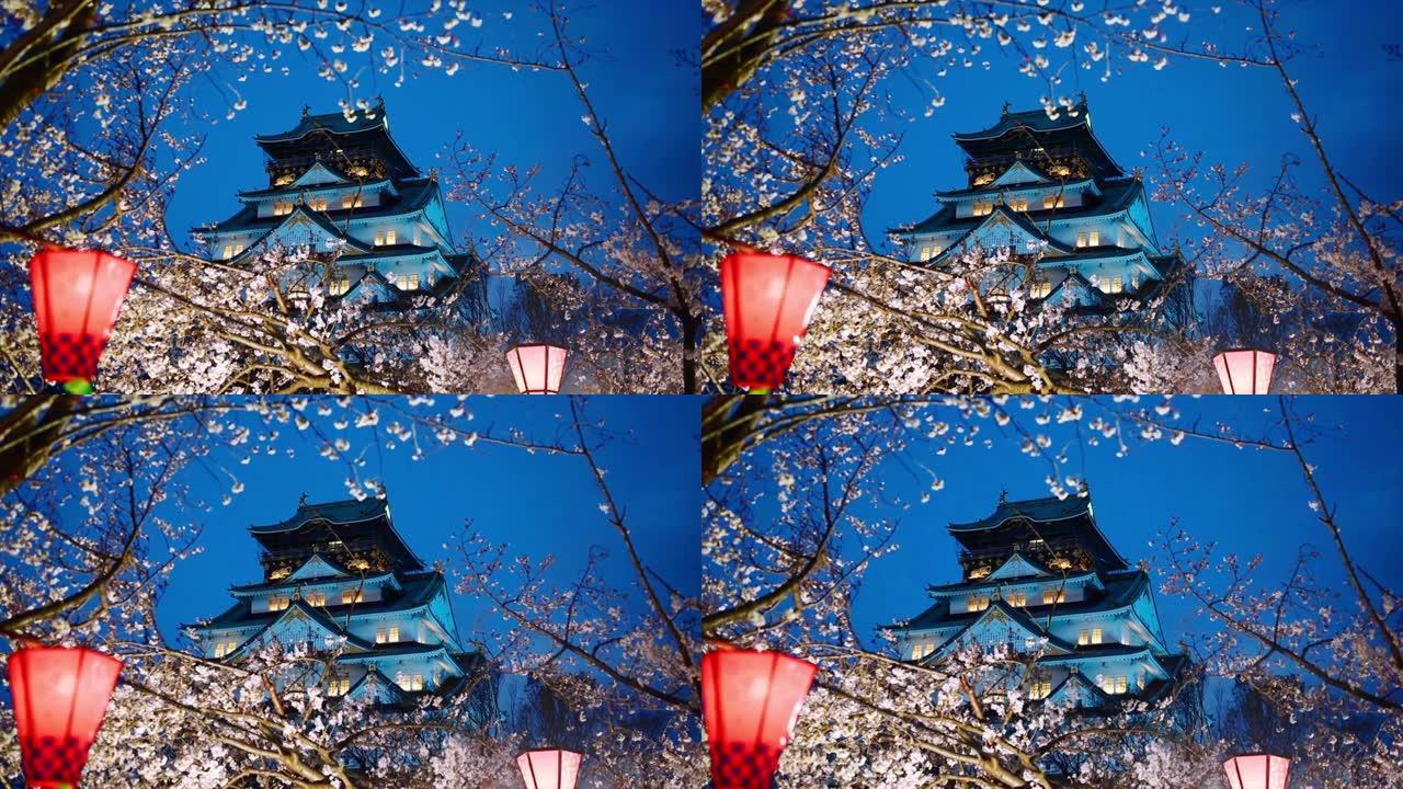 夜幕下的樱花 (樱花) 中的大阪城堡与深蓝色的天空和光线