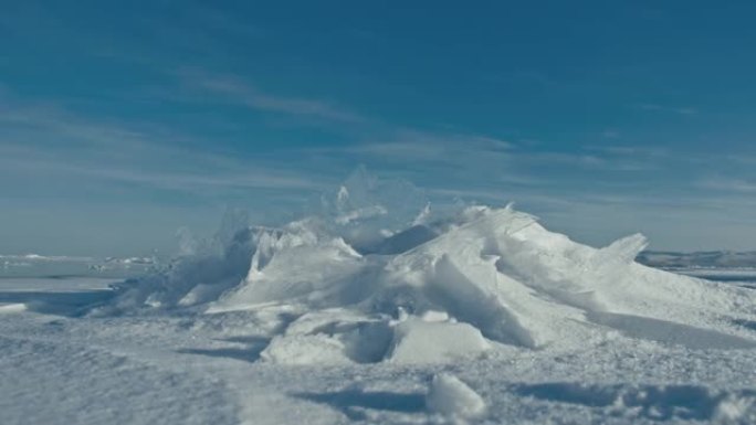 雪在冰面上飞舞。雪花在贝加尔湖的冰上飞舞。冰非常美丽，有不同寻常的独特裂缝。雪光闪烁。