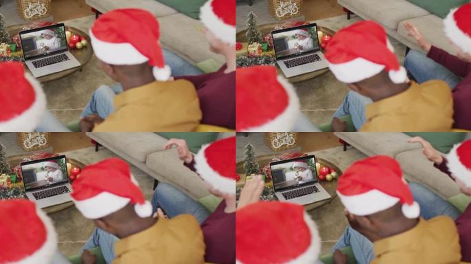 拥有圣诞老人帽子的多元化家庭使用笔记本电脑进行圣诞节视频通话，屏幕上有高加索男孩