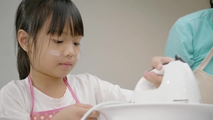 亚洲女孩在家和妹妹一起搅拌面团自制饼干，生活方式理念。