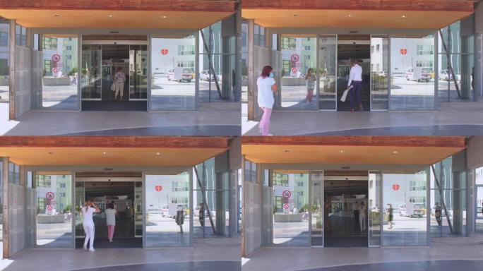 医院的自动玻璃入口门。访客和工作人员走进去。